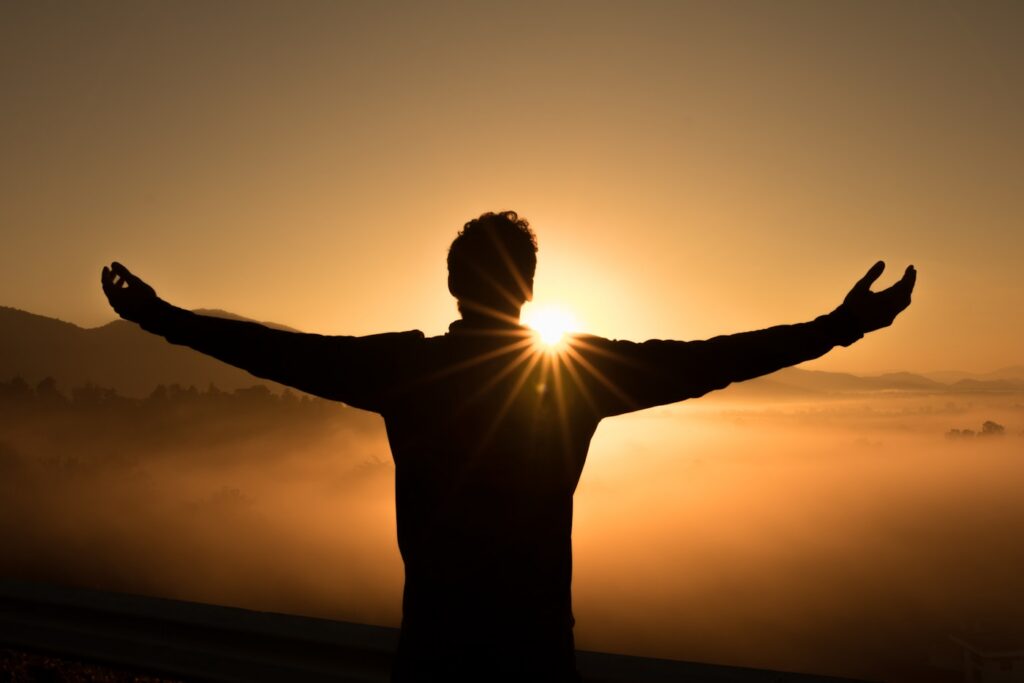 The silhouette of a person with their arms outstretched