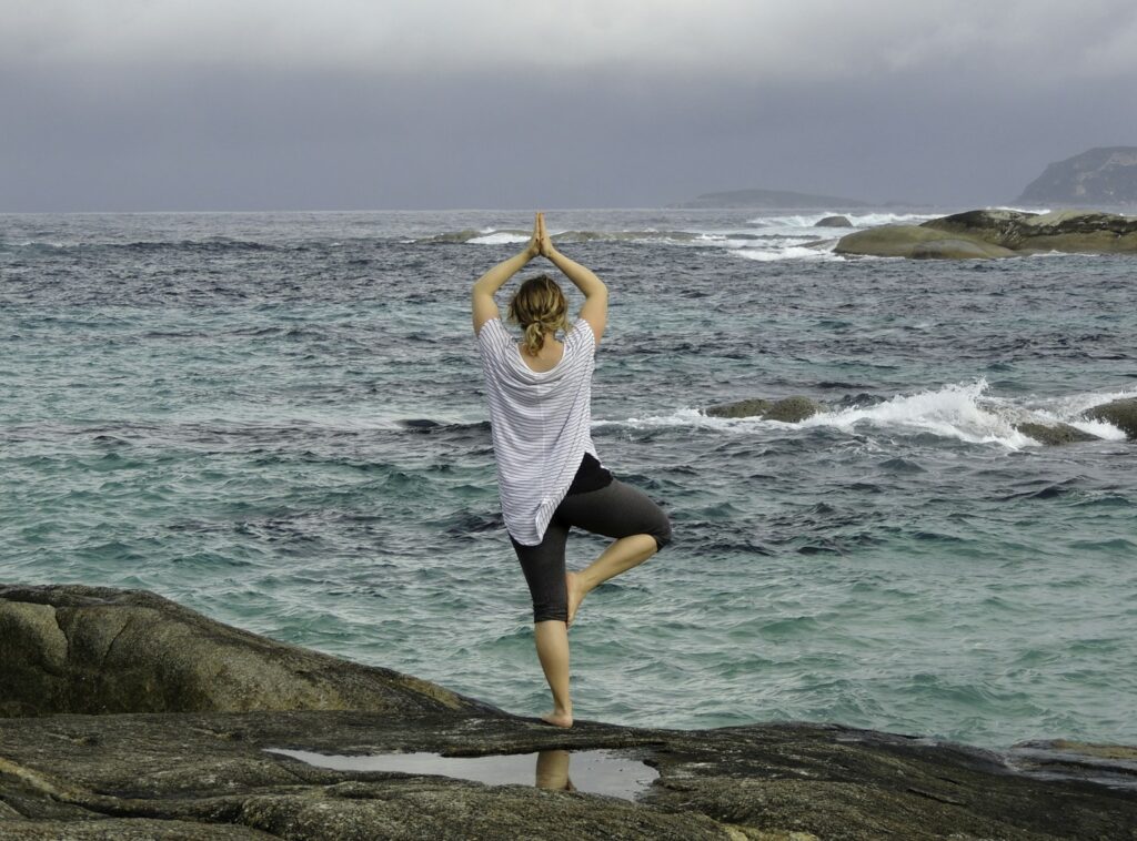 Woman doing yoga on the beach