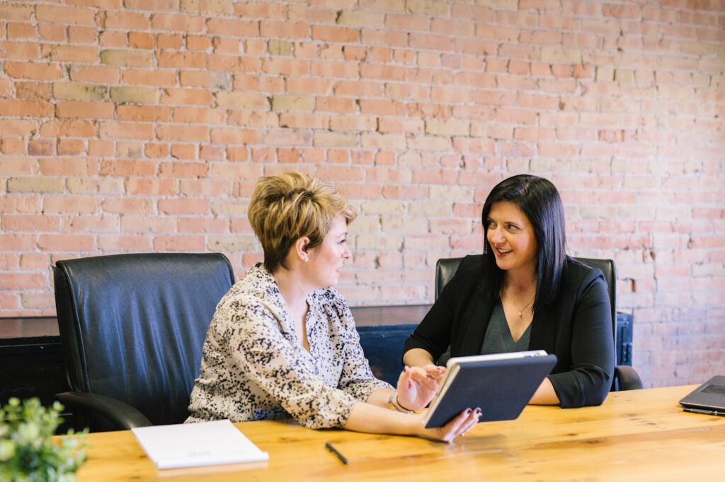 Two people talking at a desk